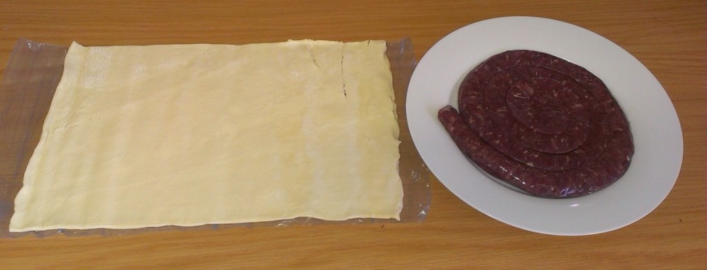 Coil of boerewors and sheet of puff pastry.