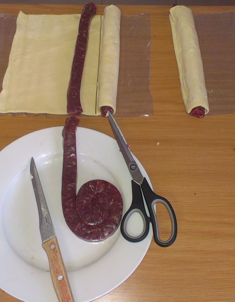 Third length of wors laid out with two lengths rolled up.