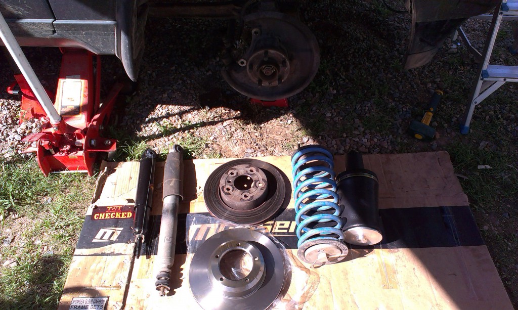 Old and new parts for a coil to air suspension conversion and front brake replacement.